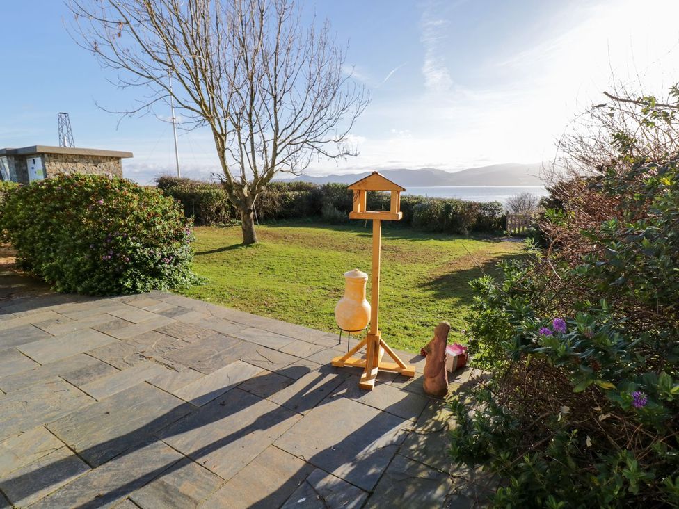 A garden with a bird feeder and plants at 2 Old Coastguard House Beaumaris