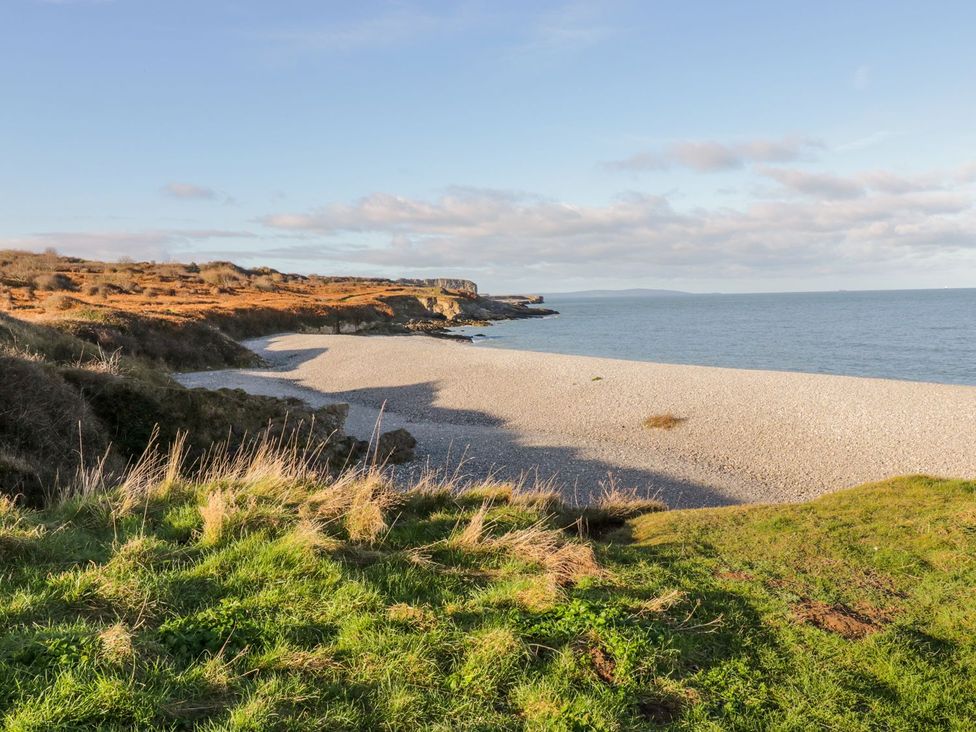 A beach with pebbles and grass at 2 Old Coastguard House Beaumaris
