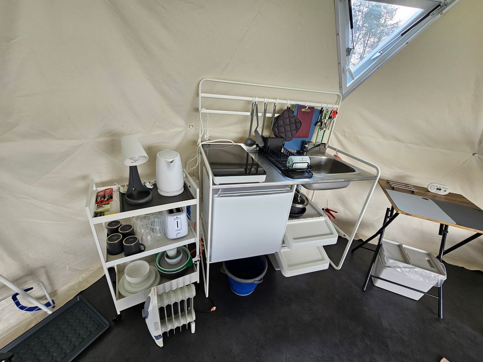 A kitchen setup with a sink, stove, and storage at Sherwood - Geodome in Mansfield