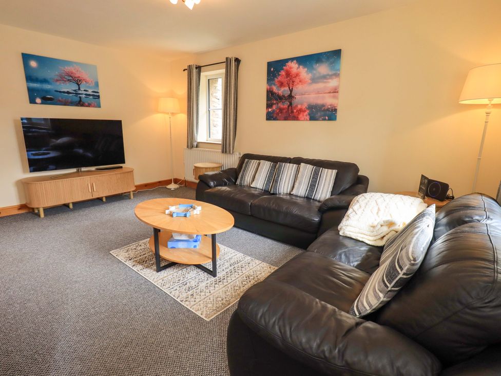A living room with a sofa and television at 4 Mellbecks Mews in Kirkby Stephen