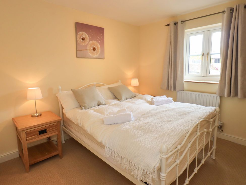 A bedroom with a bed and bedside table at 4 Mellbecks Mews Kirkby Stephen
