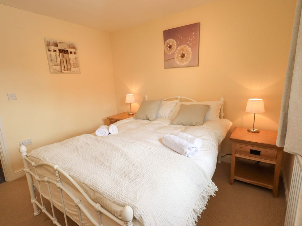 A bedroom with a bed and side tables at 4 Mellbecks Mews in Kirkby Stephen