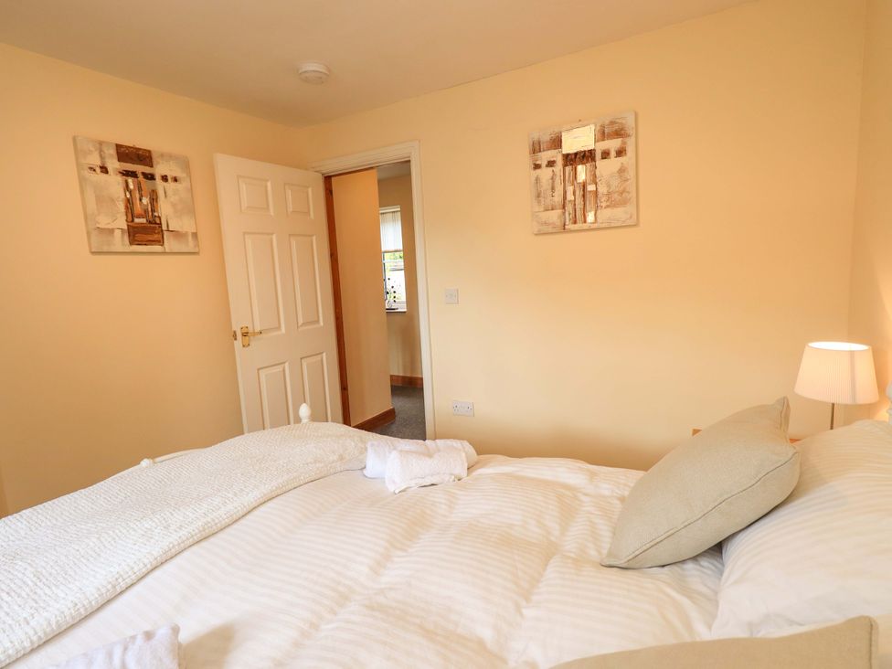 A bedroom with a bed and door at 4 Mellbecks Mews Kirkby Stephen