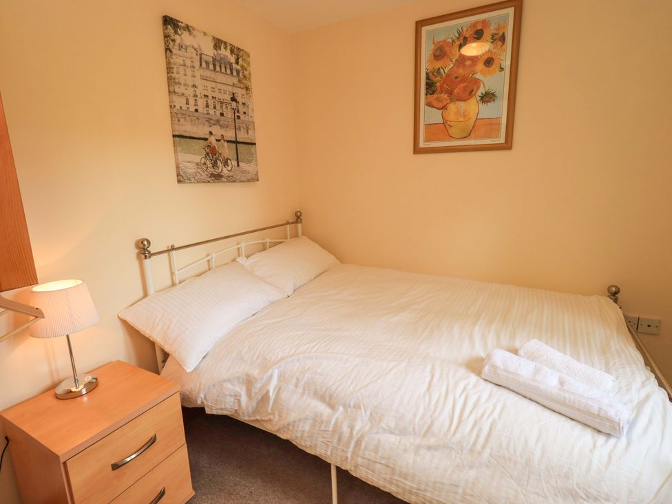 A bedroom with a bed and bedside table at 4 Mellbecks Mews Kirkby Stephen