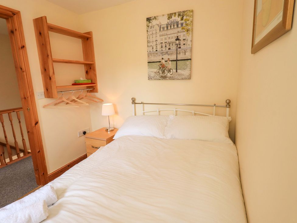 A bedroom with a bed and a shelf at 4 Mellbecks Mews Kirkby Stephen