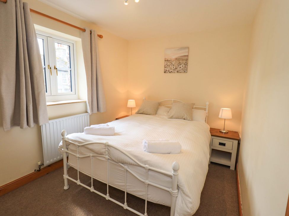 A bedroom with a bed and lamps at 4 Mellbecks Mews Kirkby Stephen