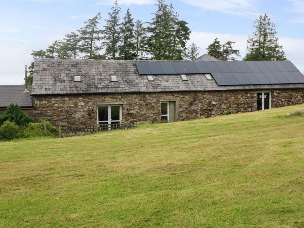 A house with solar panels and grass in front at Childwall Cottage TULLOGHER