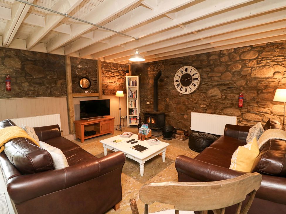 A living room with a television and bookshelf at Childwall Cottage in TULLOGHER
