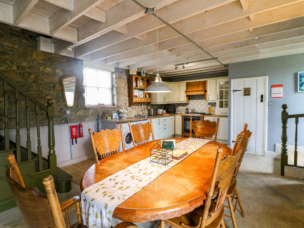 A dining room with a wooden table and chairs at Childwall Cottage TULLOGHER