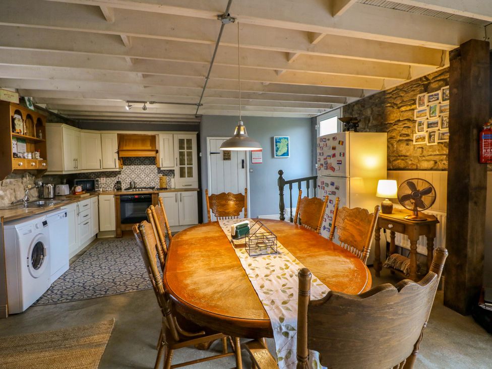 A kitchen with a dining table and chairs at Childwall Cottage in TULLOGHER
