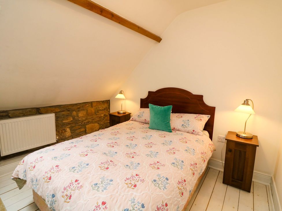 A bedroom with a bed and nightstand at Childwall Cottage TULLOGHER
