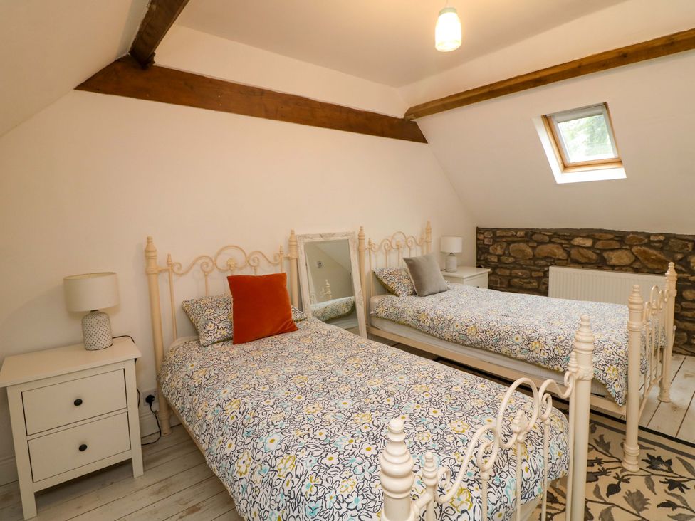 A bedroom with two beds and a nightstand at Childwall Cottage TULLOGHER