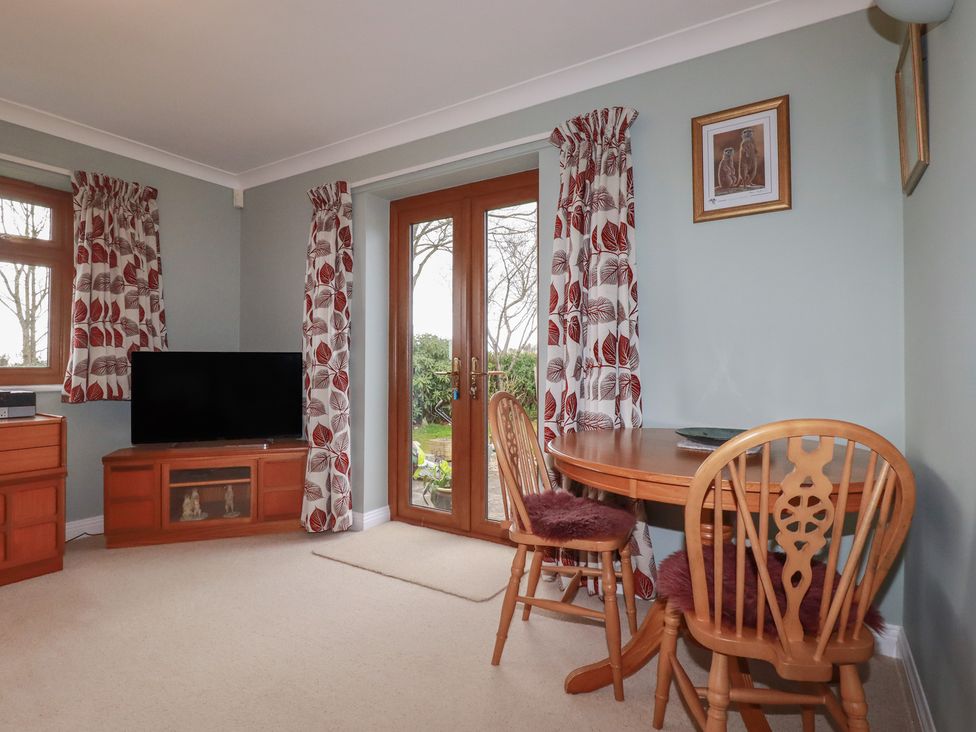 A dining area with a table and chairs at Honeysuckle Rise in Looe