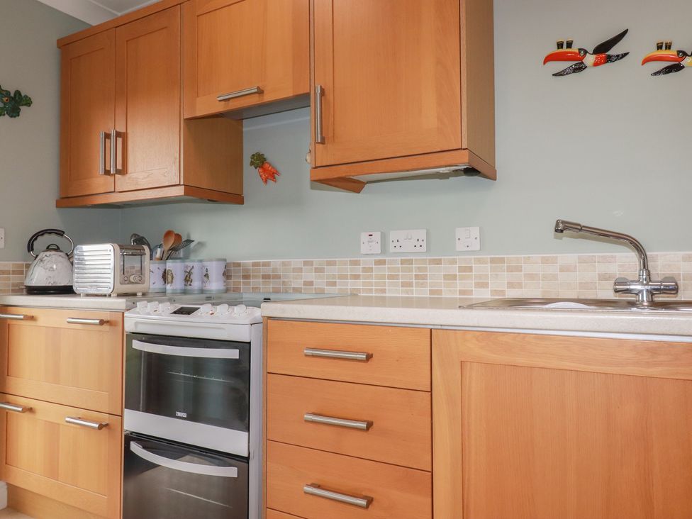 A kitchen with appliances and cabinetry at Honeysuckle Rise in Looe