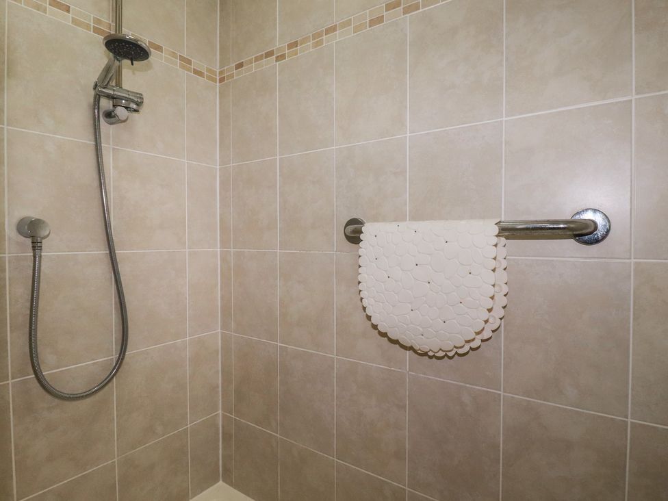 A shower area with a towel rail at Honeysuckle Rise in Looe