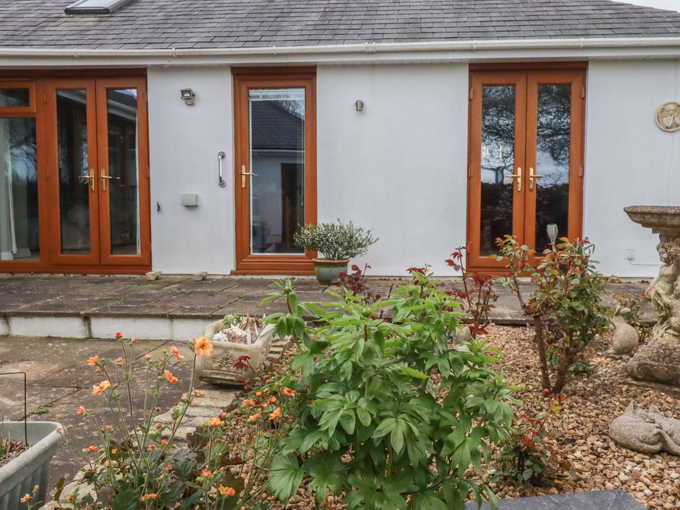 An outdoor area with doors and planters at Honeysuckle Rise in Looe