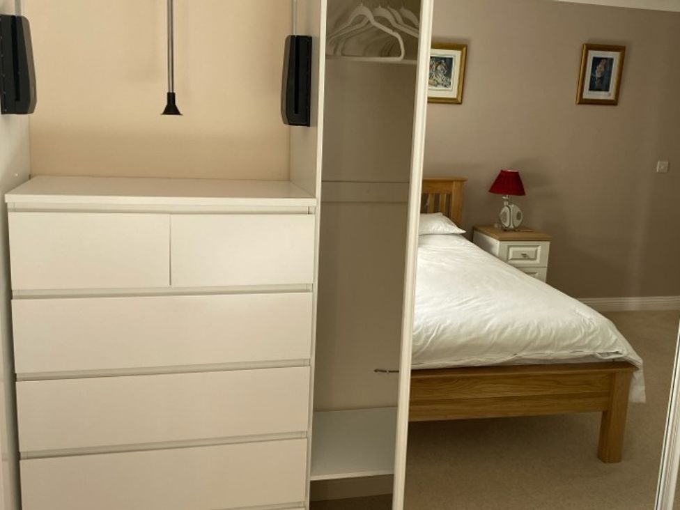 A bedroom with a bed and furniture at Honeysuckle Rise in Lanreath