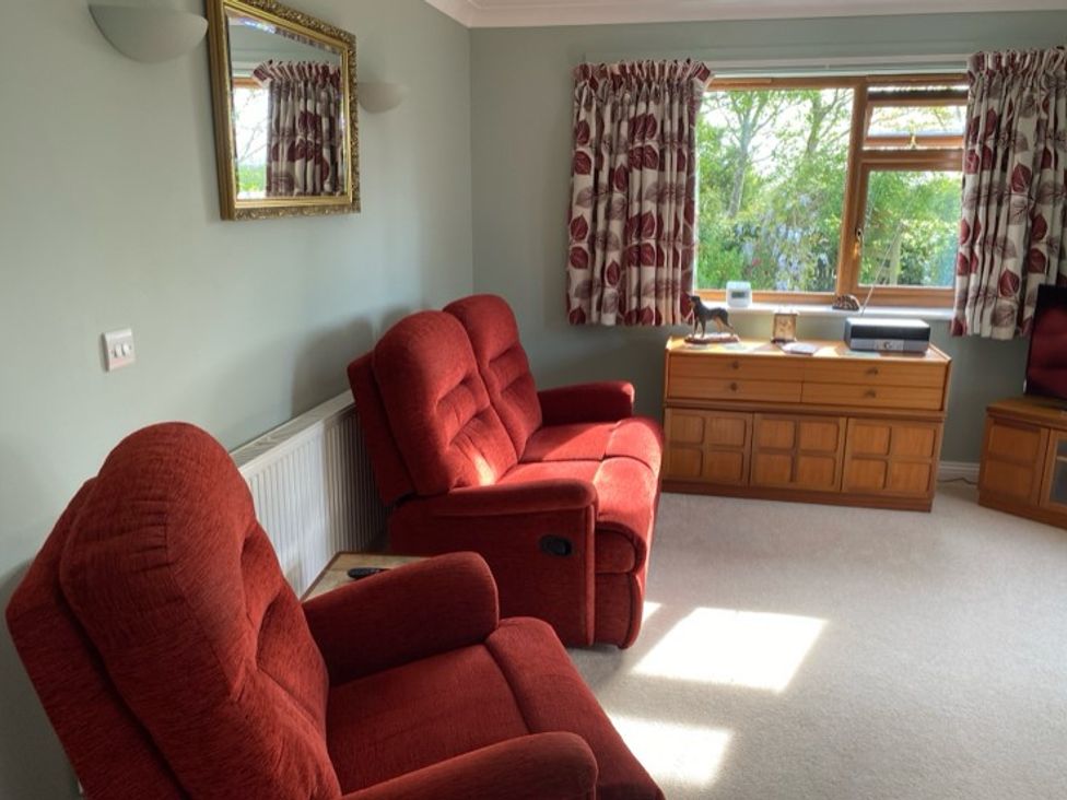 A living room with recliner chairs and a window at Honeysuckle Rise in Lanreath