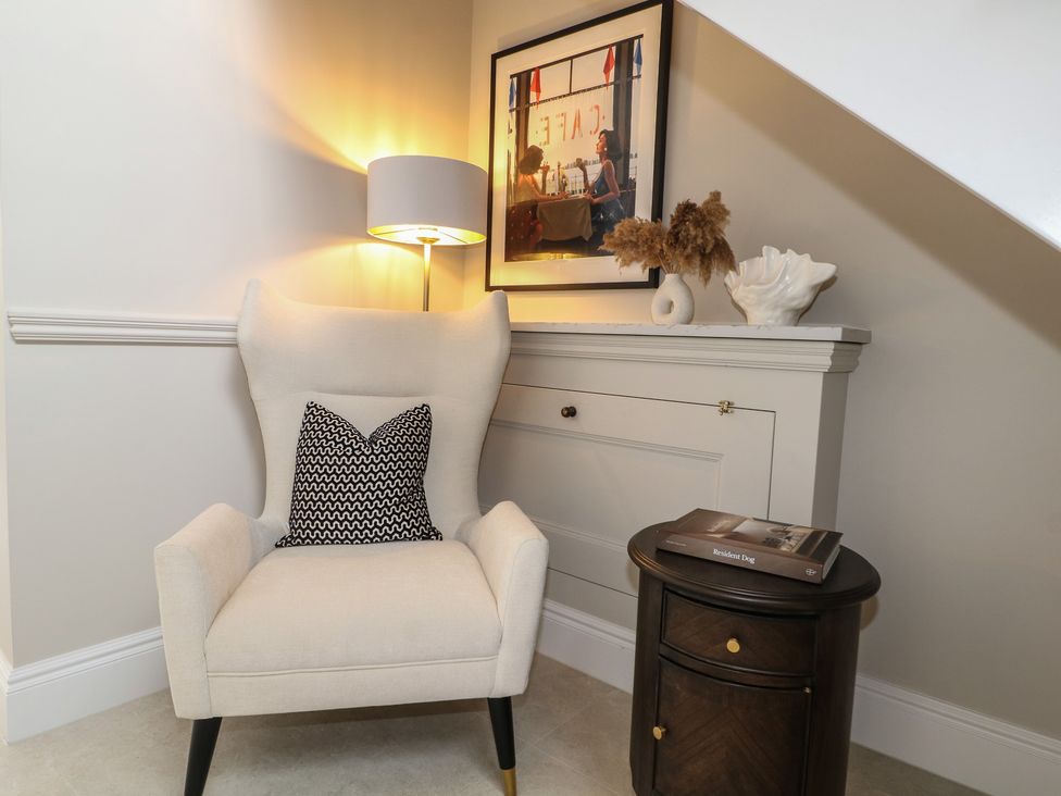 A cozy seating area with an armchair and table at Sea Estate House in Littlehampton