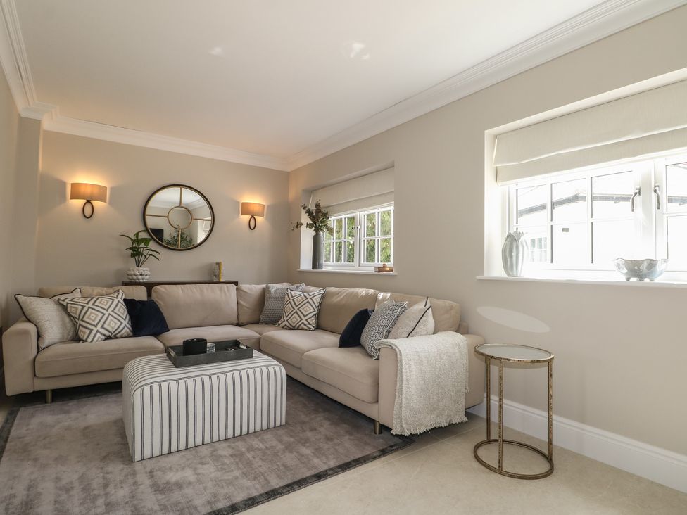 A living room with a sofa, coffee table and wall lights at Sea Estate House in Littlehampton