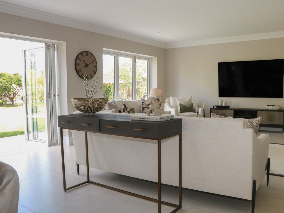A living room with a sofa and a television at Sea Estate House in Littlehampton