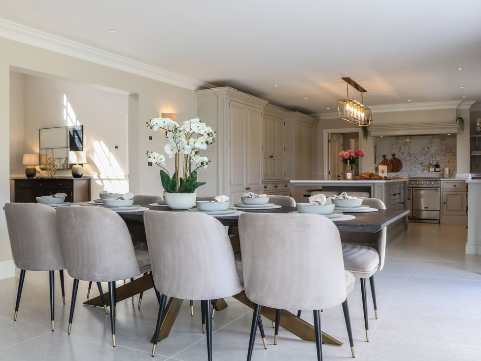 A kitchen with a dining table and flower arrangement at Sea Estate House in Littlehampton
