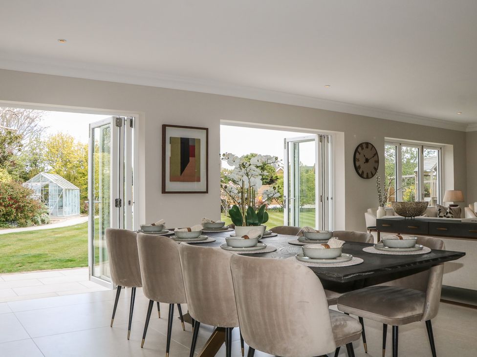 A dining room with a table set for meals at Sea Estate House in Littlehampton