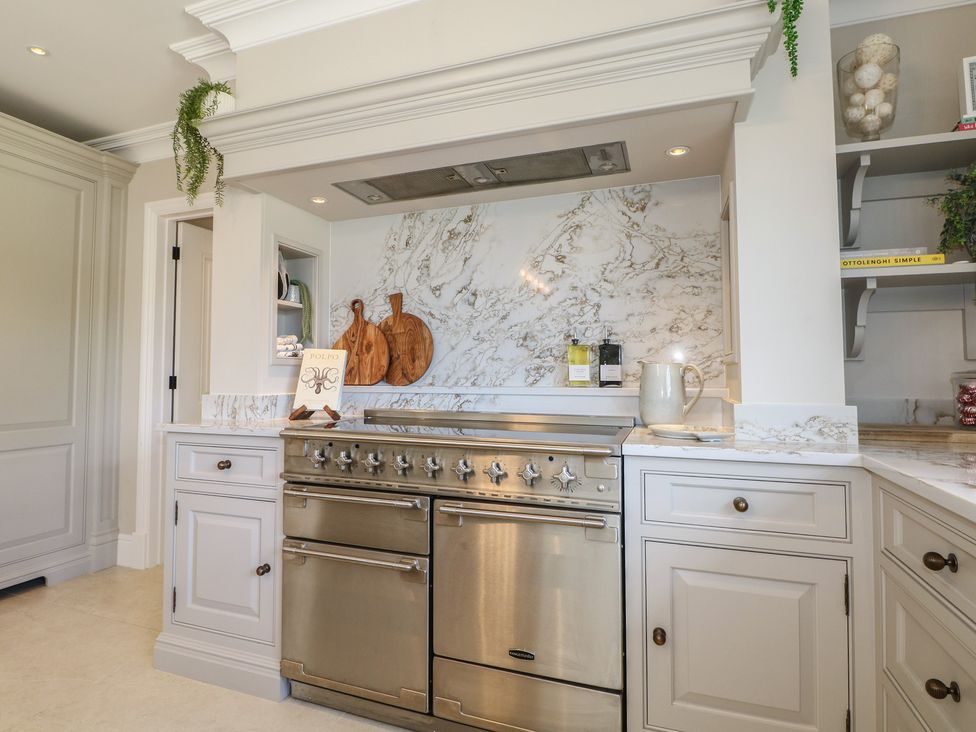 A kitchen with stove and marble backsplash at Sea Estate House in Littlehampton