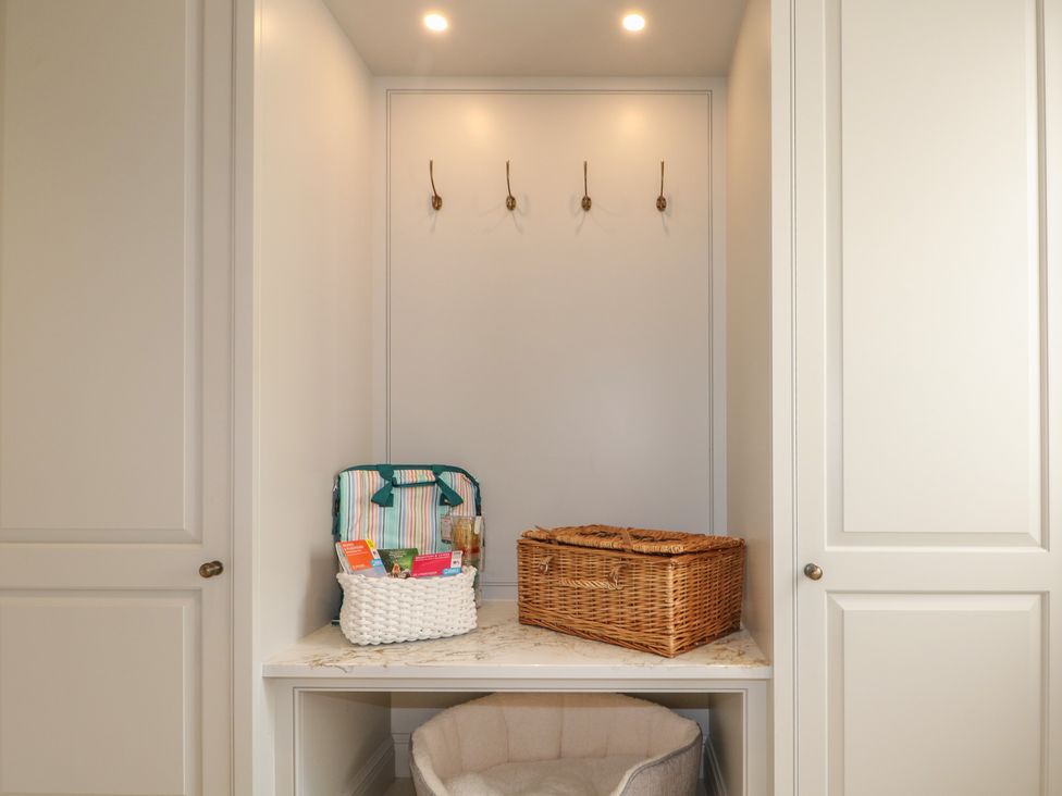 A hallway with hooks, baskets, and a pet bed at Sea Estate House in Littlehampton