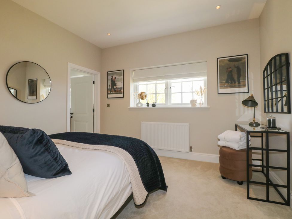 A bedroom with a bed and mirror at Sea Estate House in Littlehampton