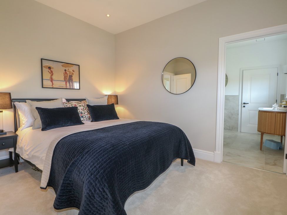 A bedroom with a bed and mirror at Sea Estate House Littlehampton
