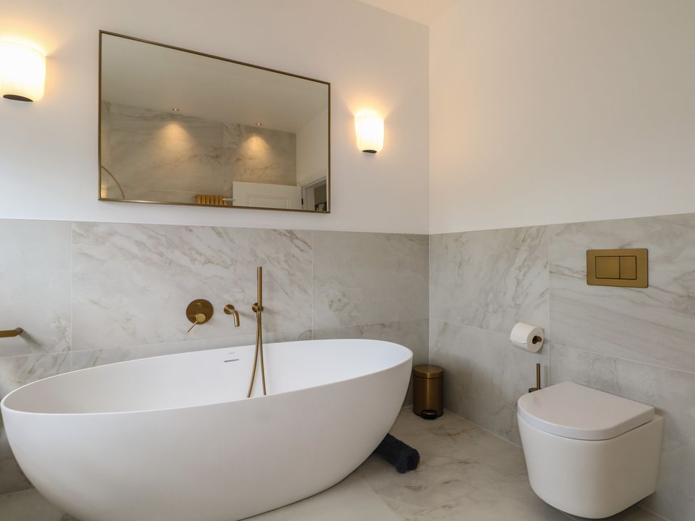 A bathroom with a bathtub and toilet at Sea Estate House in Littlehampton
