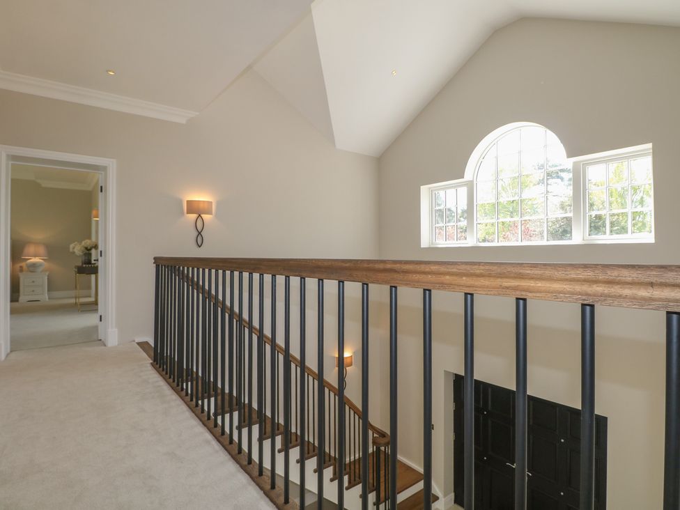 A hallway with a staircase and lamp at Sea Estate House in Littlehampton