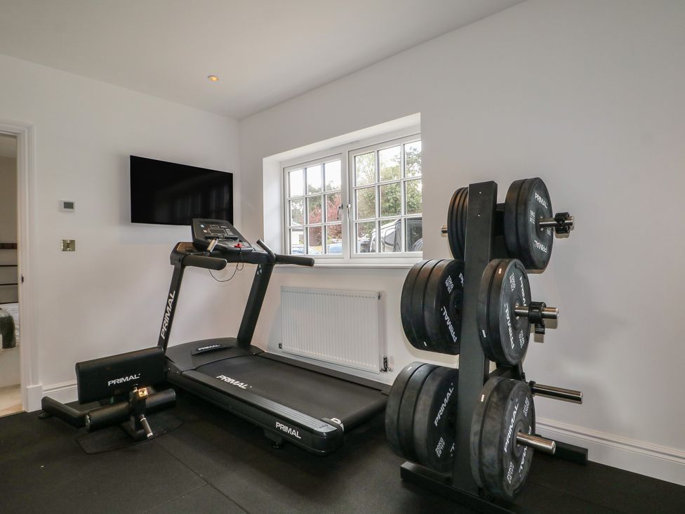 A gym with a treadmill and weight rack at Sea Estate House in Littlehampton