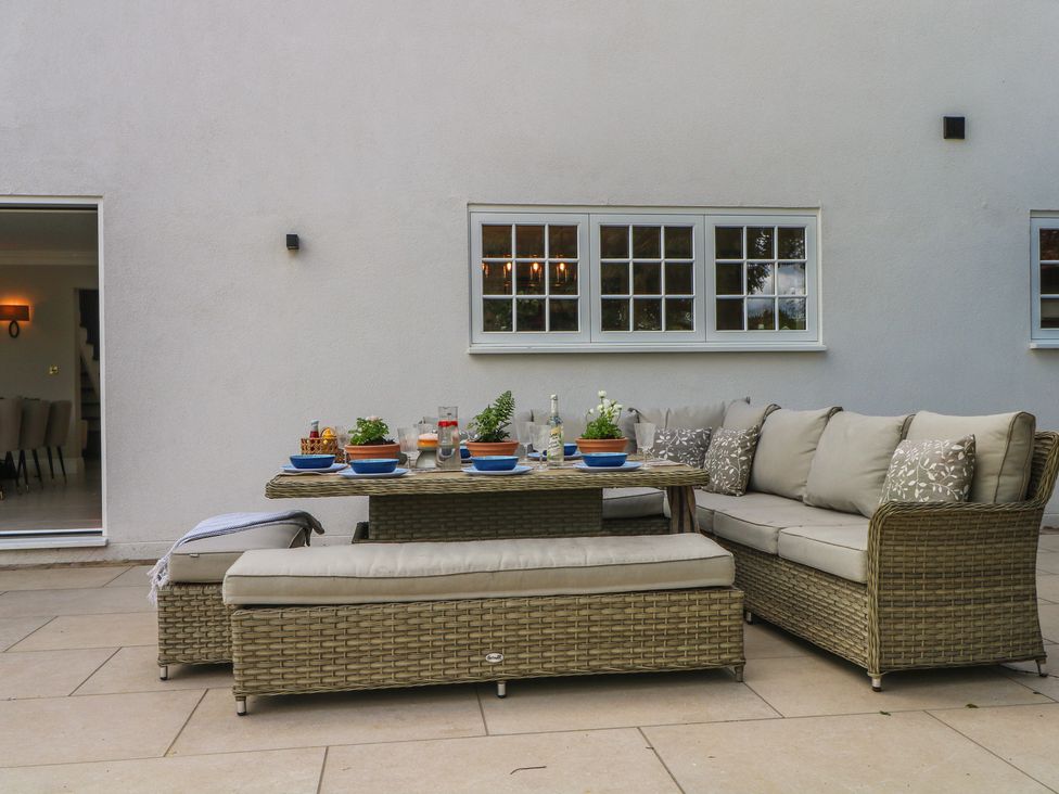 A patio with a couch and table set up at Sea Estate House in Littlehampton