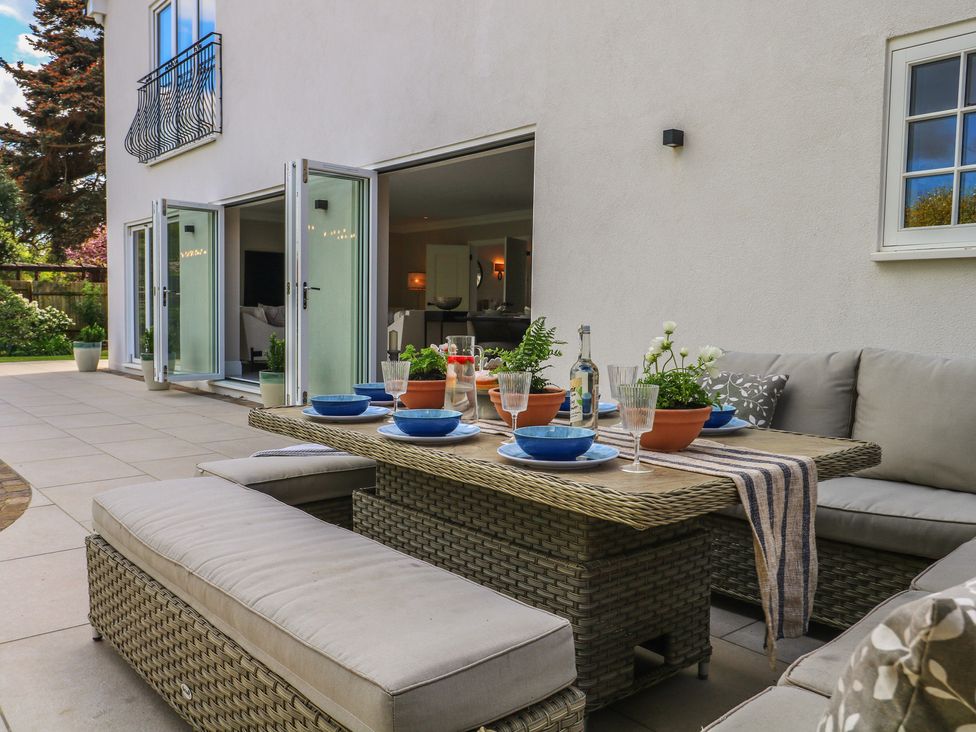 An outdoor dining area with table set for a meal at Sea Estate House in Littlehampton