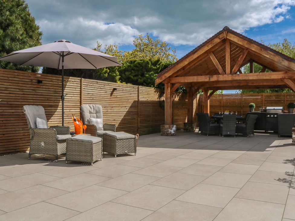 A garden with seating and a pergola at Sea Estate House in Littlehampton