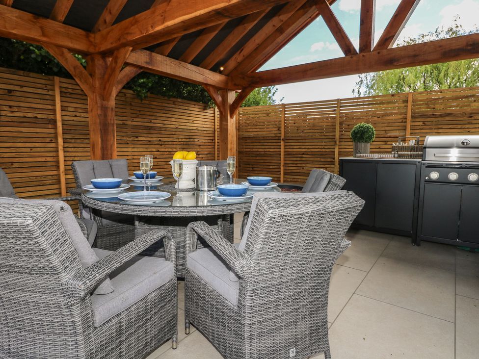 An outdoor patio with a table and grill at Sea Estate House in Littlehampton