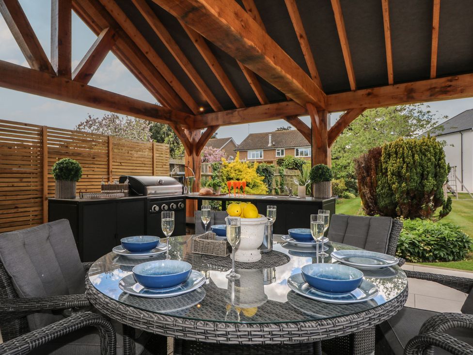 An outdoor dining area with a table set for several guests at Sea Estate House in Littlehampton