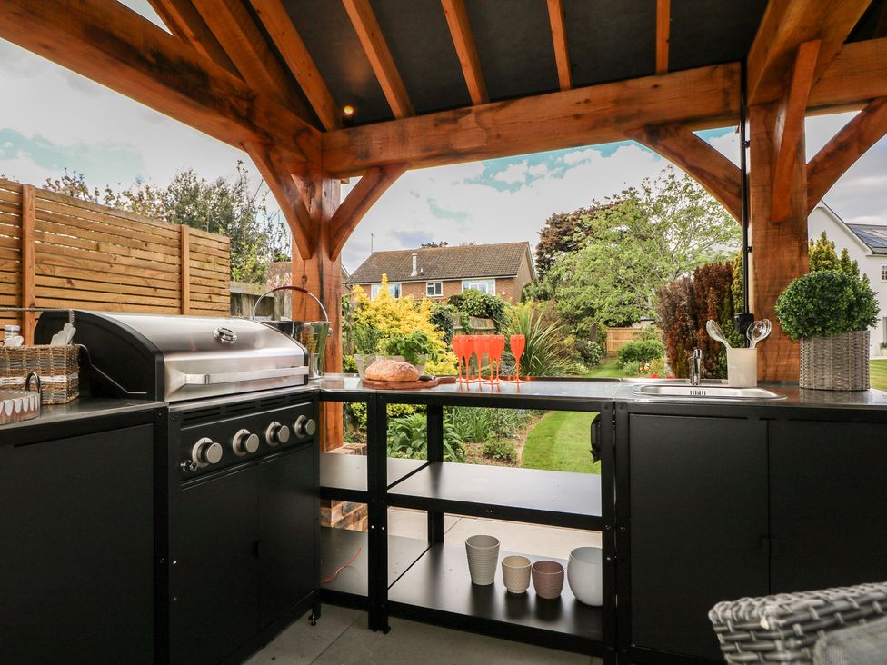 An outdoor kitchen with grill and sink at Sea Estate House in Littlehampton