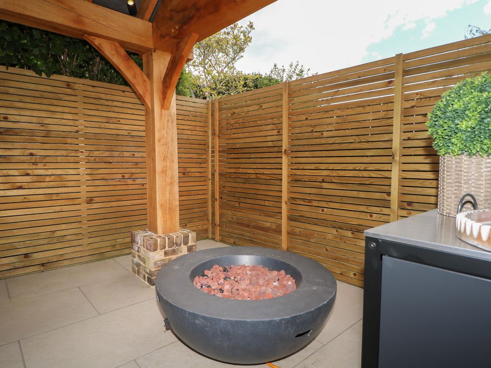 An outdoor area with a fire pit and wooden fence at Sea Estate House in Littlehampton