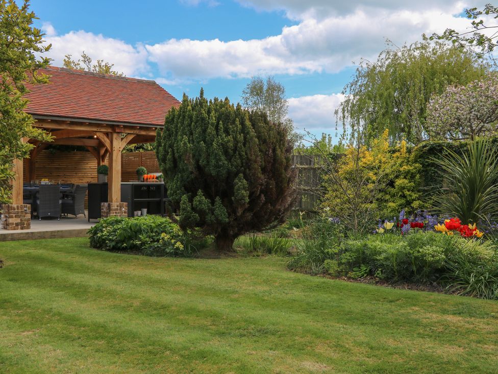 A garden with flower beds and an outdoor seating area at Sea Estate House Littlehampton