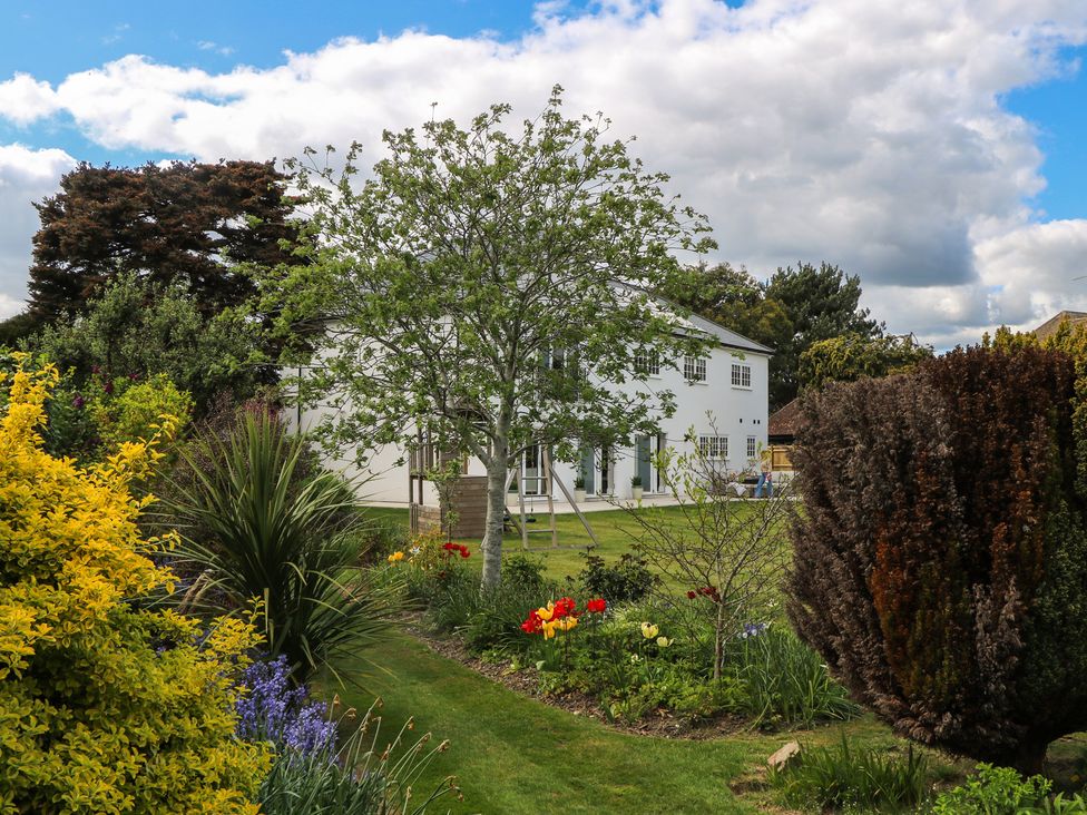 A garden with flowers and trees at Sea Estate House in Littlehampton