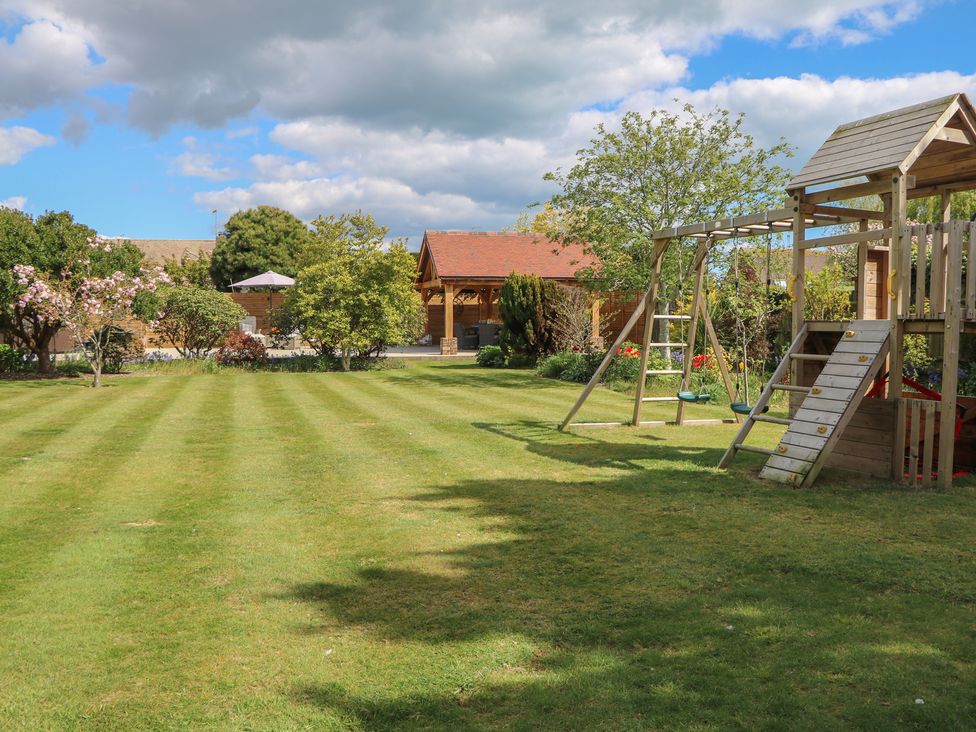 A garden with a playground and seating area at Sea Estate House in Littlehampton
