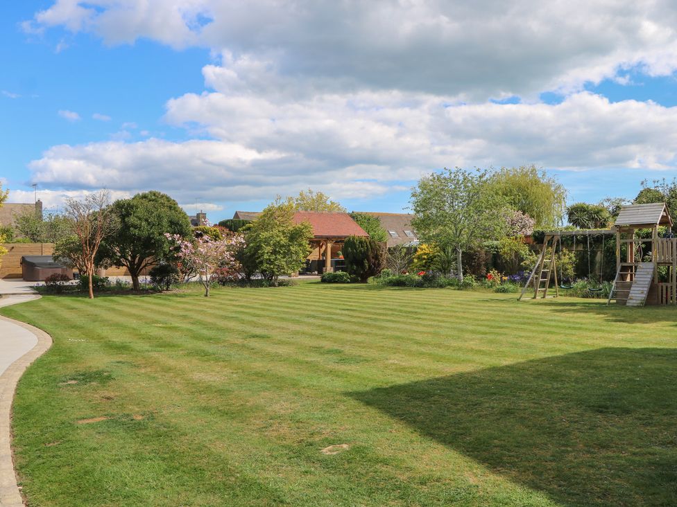 A garden with a lawn and playset at Sea Estate House Littlehampton