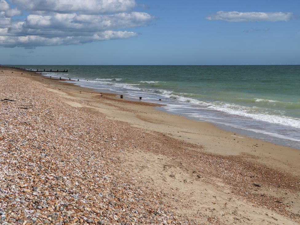 A beach with sand and shells at Sea Estate House in Littlehampton