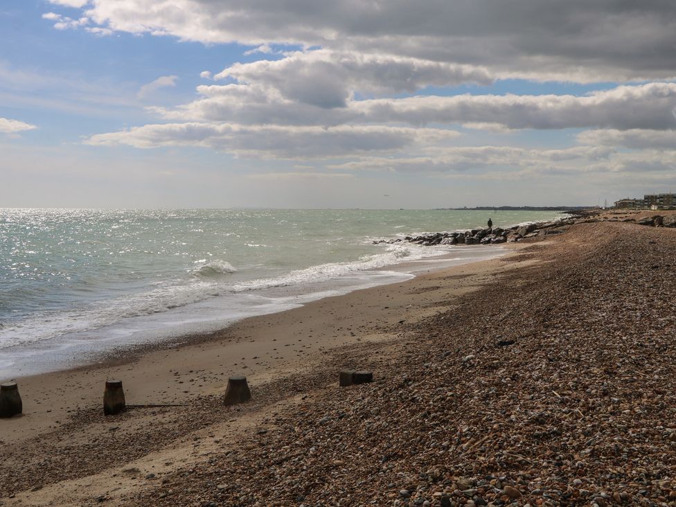 A beach with pebbles and rocks along the ocean at Sea Estate House in Littlehampton