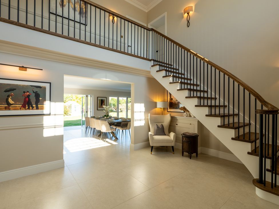 A hallway with a staircase leading to an upper level at Sea Estate House Rustington