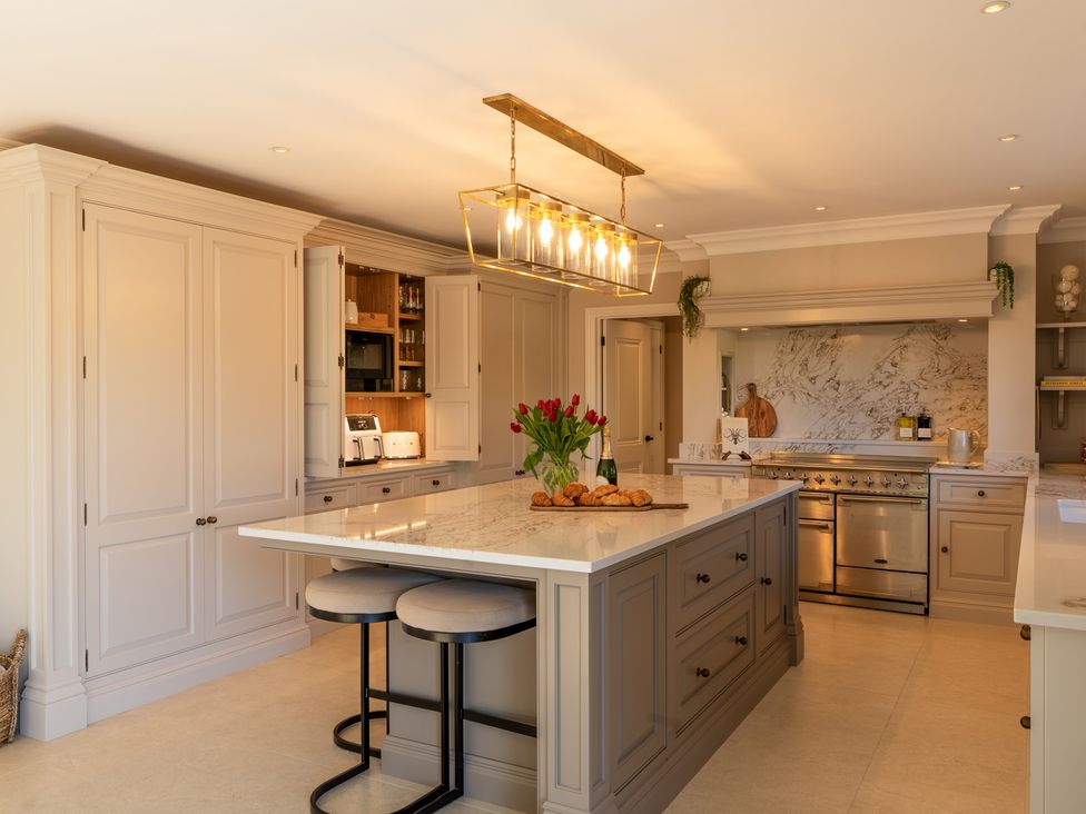 A kitchen with cabinets an island and appliances at Sea Estate House in Rustington
