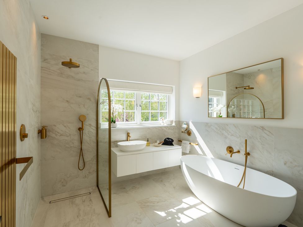 A bathroom with a bathtub and sink at Sea Estate House in Rustington